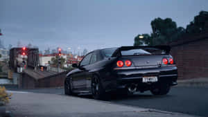 黑色日產Skyline GT-R在橋上，背景有城市燈光（黃昏）。 — 汽車 壁紙