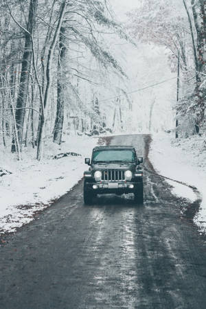 冬季積雪森林道路上的黑色吉普車