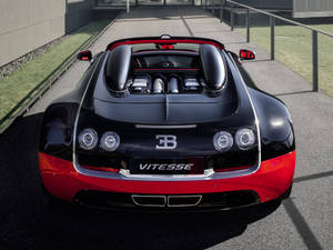 黑色和紅色的Bugatti Vitesse超級跑車，露出引擎，停在鋪砌表面上。