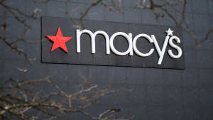 Macy's 商店標誌，灰色牆上紅色星星，由光禿樹枝框住