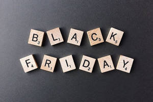 在深灰色背景上用木製 Scrabble 字母牌拼出 Black Friday。 — 型格黑色 壁紙
