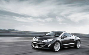 黑色Peugeot RCZ跑車在高速公路上飛馳，帶有動態模糊效果。