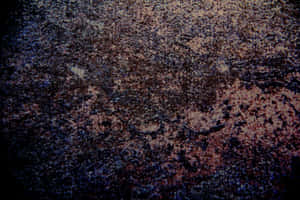 粗糙紋理表面的特寫，帶有深藍色和鏽褐色色調。