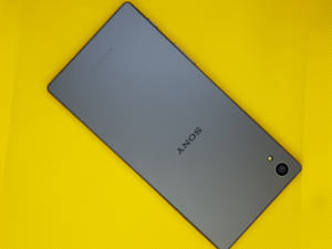 灰色Sony Xperia手機在明亮的黃色紋理背景上 — 黑色電話 壁紙