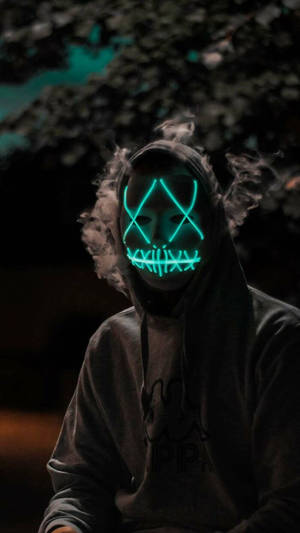 戴著發光綠色LED面具的人在夜間呼出煙霧。