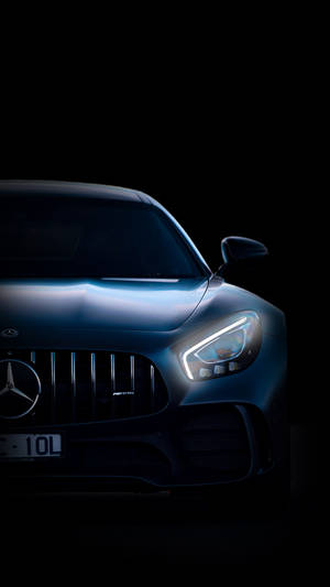 在黑暗中閃爍車頭燈的時尚藍色 Mercedes-AMG 跑車。