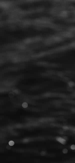 黑暗的漣漪水面，帶有柔和發光的光圈。