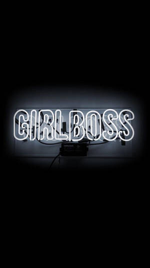 一個明亮的白色霓虹燈牌，在深色背景上顯示「GIRLBOSS」。