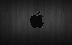黑色Apple標誌在深色木紋背景上。
