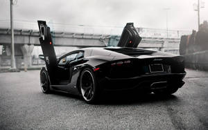 黑色林寶堅尼 Aventador 在都市道路上打開鷗翼車門，黃昏時分。