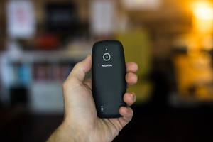 手拿著帶相機鏡頭的黑色Nokia手機 — Nokia 壁紙