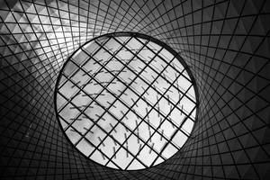 黑白建築天花板，帶有圓形天窗和幾何網格圖案。