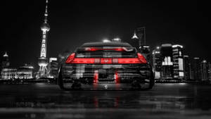 黑色跑車帶紅色燈光夜晚停在上海天際線前