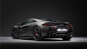 啞光灰色McLaren 570S跑車，在工作室燈光下帶有紅色點綴。 — 麥拿侖 GIF 壁紙