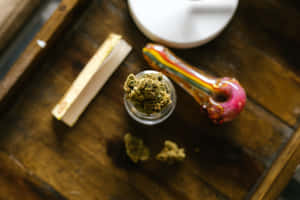 罐子裡的大麻花蕾，配上彩色煙斗和捲煙紙，置於木托盤上。