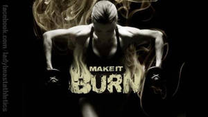 一個女人在火焰和煙霧環繞下舉重，帶有「MAKE IT BURN」文字。 — 健身 壁紙