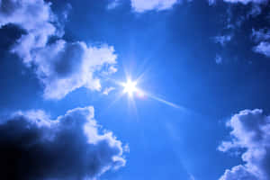 太陽在清澈的藍天中透過白雲明亮地照耀。