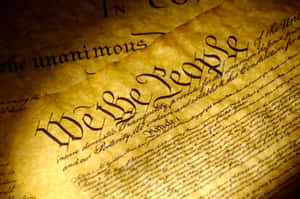 古老羊皮紙上溫暖光線下的美國憲法開篇文字的特寫。