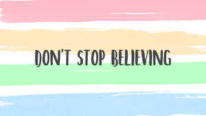 勵志名言 'don't stop believing' 在粉彩筆觸背景上。