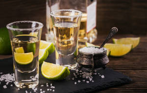 兩杯龍舌蘭酒，配以鹽和青檸，置於石板托盤上。